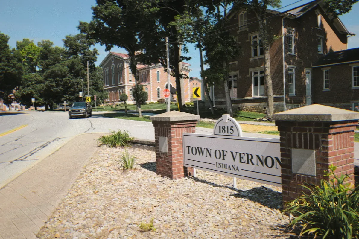 A peaceful, sunlit street in Vernon with a historic courthouse in the distance